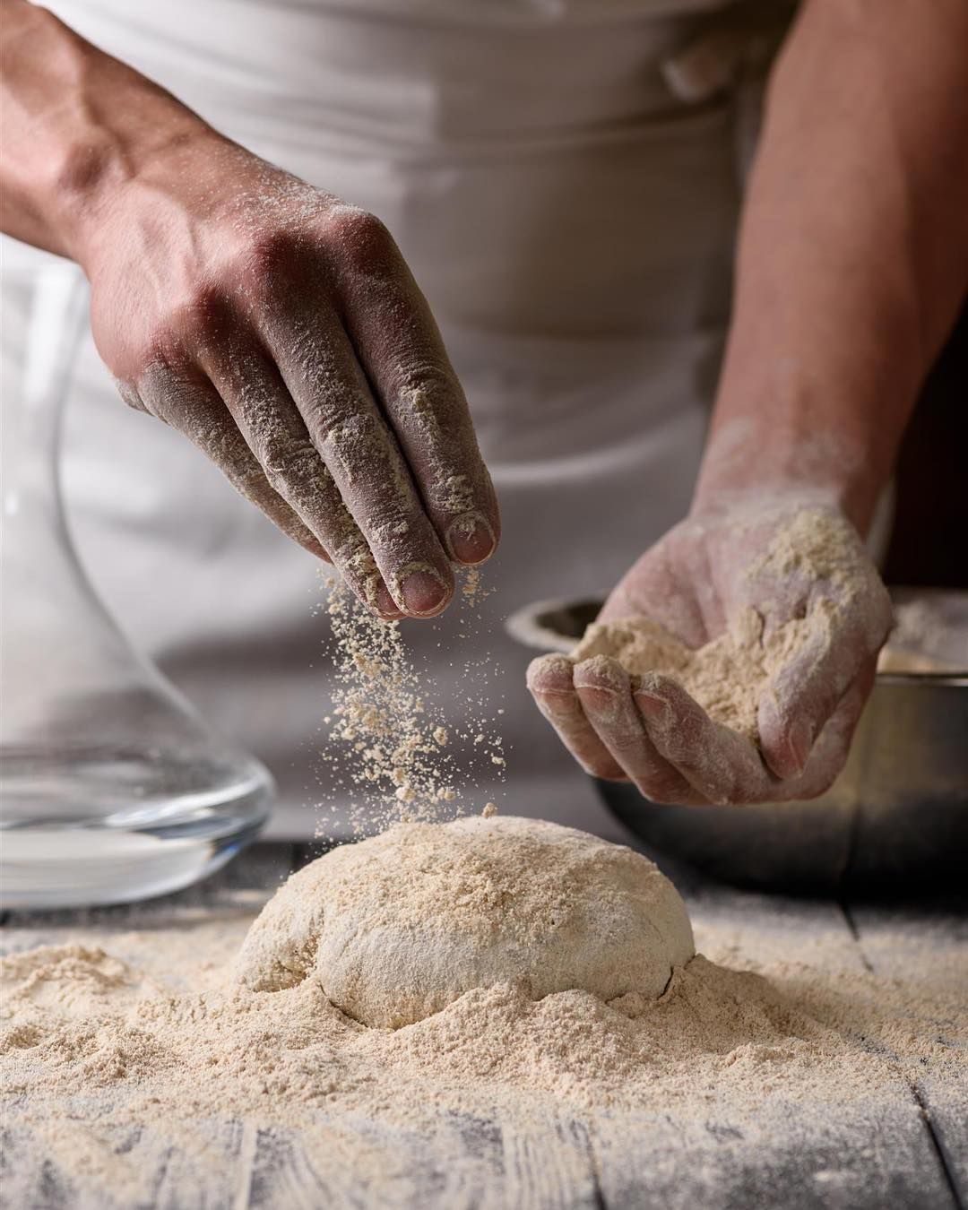 Mani che lavorano l'impasto della focaccia con la farina